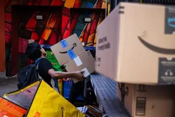 A worker in New York unloading packages from online agent Amazon, which has blocked agentic shopping.